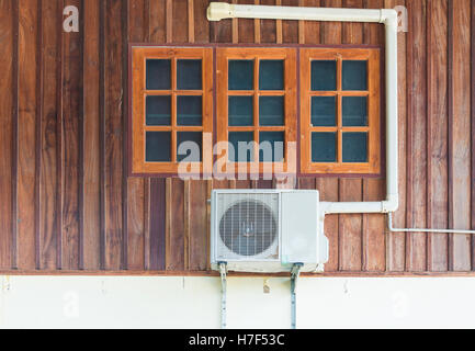 Eine Klimaanlage installiert außerhalb des Hauses auf Holzwand Stockfoto