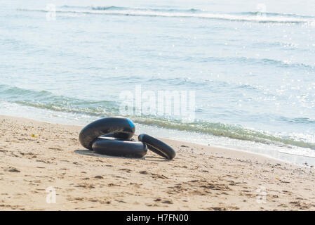 Rettungsring aus Innenrohr schwarze Farbe am Strand in Thailand Stockfoto