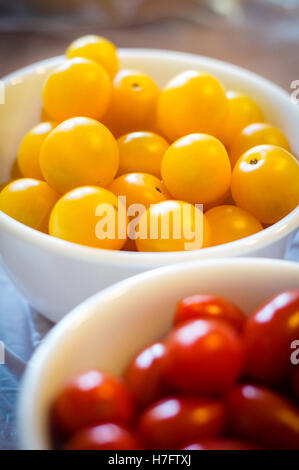 Gelbe Cherry-Tomaten mit geringen Schärfentiefe auf Vordergrund rote Tomaten im Fokus Stockfoto