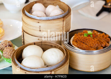 Gedämpfte chinesische Dim-Sum serviert im Bamboo Steamer, einschließlich Brötchen, geschmortem Rindfleisch Tripes und Garnelen Knödel. Stockfoto