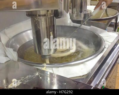 Churros Ausarbeitung. Churros-Hersteller Braten Gebäck Dought in Spiralform Stockfoto