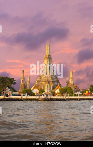 Wat Arun, der Tempel der Morgenröte, liegt entlang des Chao Phraya Flusses bei Sonnenaufgang am Morgen mit einem feurigen roten Himmel in Bangkok, Thailand Stockfoto