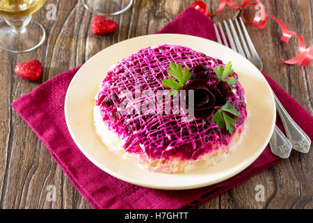 Festliche Salat Hering unter einem Pelzmantel (aus rote Beete, Eiern, Hering, Kartoffeln, Käse, Karotten) auf den alten hölzernen Hintergrund. Stockfoto