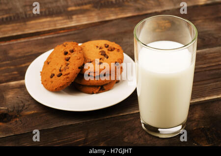 Milch mit Schokolade Haferflocken Cookies auf einem Holztisch Stockfoto