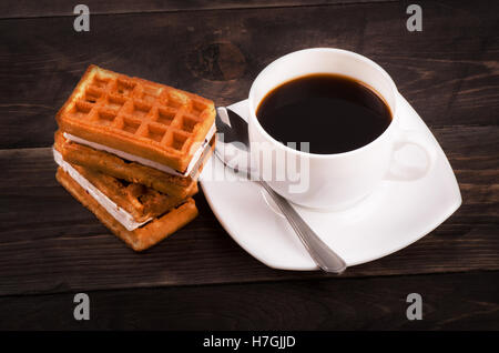 Kaffee, Löffel und Wiener Waffeln auf einem Holztisch Stockfoto