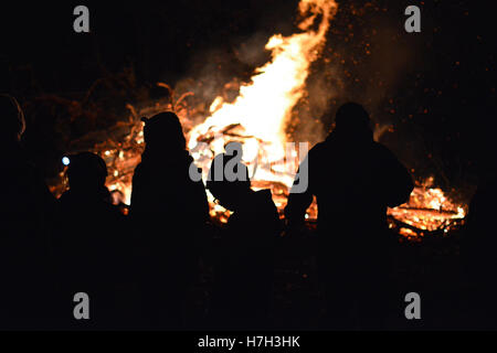 Bonfire Night Silhouette aus einem ländlichen Lagerfeuer Nacht Guy Fawkes Feier in Nord-Wales am Freitag, 4. November 2016, war dies ein lokales ausführen Lagerfeuer von der Community für die Community, mit BBQ essen, Suppe und heißen Getränken. Jedes Jahr kommen diese Gruppe von Menschen zusammen, helfen, Spenden, so dass Einheimische ein großes Spektakel aus Feuer und Feuerwerk genießen Stockfoto