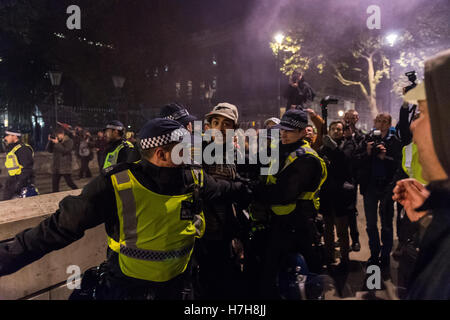 London, UK. 5. November 2016. Polizisten verhaften einer der Demonstranten auf Whitehall, Downing Street. Tausende von Demonstranten versammeln sich im Zentrum von London zur Teilnahme an der jährlichen "Million Mask März" organisiert seit 2011 von der anonymen britischen kollektiven. Die Veranstaltung ist Teil der globalen Anti-Establishment und antikapitalistischen Protest gegen Probleme wie Sparsamkeit, Verletzung der Menschenrechte, Überwachung, Politik und Wirtschaft. Guy Fawkes Maske, oft getragen von den AktivistInnen ist weltweit als Symbol für die Anonymous-Bewegung anerkannt. Wiktor Szymanowicz/Alamy Live-Nachrichten Stockfoto