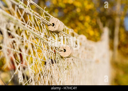 Kleine Kork schwimmt auf Netzstrümpfe zum Trocknen gehängt. Flachen Fokus auf Schwimmer und unscharfen Hintergrund. Stockfoto