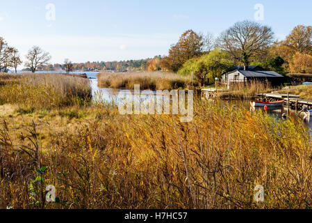 Vieryd, Schweden - 29. Oktober 2016: Dokumentation der küstennahen Lebensweise. Boot vor Anker in der schmalen Mündung durch eine Kabine. Viele r Stockfoto