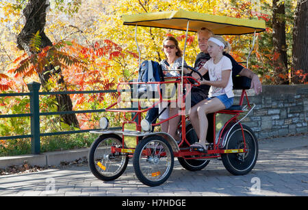 Junges Mädchen ihre Familie auf einem doppelten Surrey Fahrrad im Minnehaha Park hausieren. Minneapolis Minnesota MN USA Stockfoto