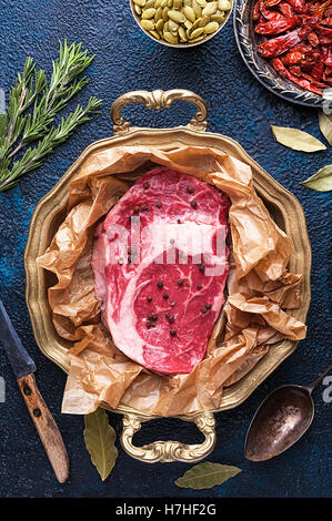 Stück Fleisch Rindfleisch auf Tablett umgeben von Gewürzen Stockfoto