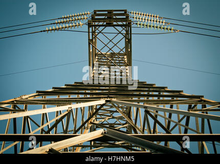 Niedrigen Winkel Seitenansicht des elektrischen Pylon gegen blauen Himmel Stockfoto