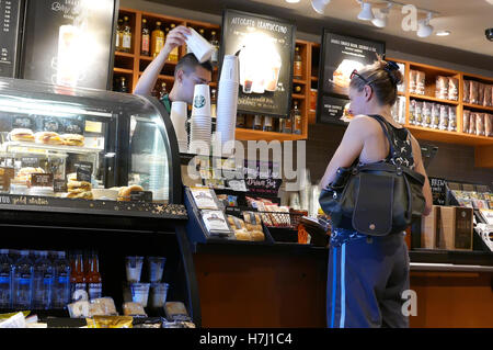 Port Coquitlam, BC, Kanada - 28. Juli 2016: Nahaufnahme Frau Kaffee kaufen und bezahlen per Kreditkarte innerhalb Starbucks Filiale Stockfoto