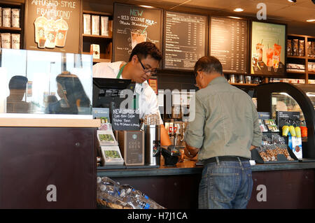 Coquitlam, BC, Kanada - 29. Juli 2016: Nahaufnahme Mann Kaffee kaufen und bezahlen per Kreditkarte innerhalb Starbucks Filiale Stockfoto