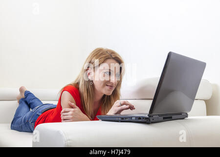 Frau mit einem Laptop auf der couch Stockfoto
