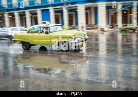 Havanna, Kuba - 18. Mai 2011: Klassische 1950er Jahren Auto fährt in Bewegung Unschärfe durch die nassen Straßen von Centro nach einem Regenschauer. Stockfoto