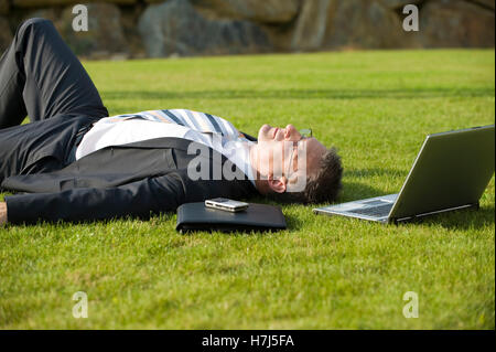 Geschäftsmann entspannend in einem park Stockfoto