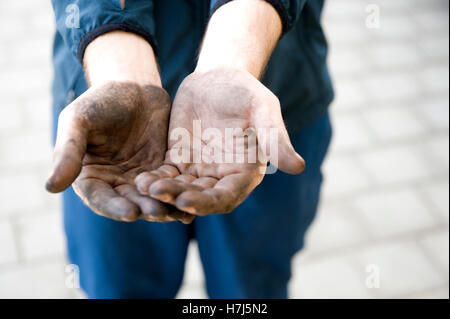 Manuelle Arbeiter mit schmutzigen Händen betteln um Geld, symbolisches Bild eines illegalen Arbeiter Stockfoto