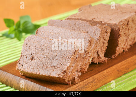 Scheiben von Schokolade Halva auf Schneidebrett Stockfoto