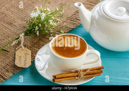 Kaffeebecher mit weißen Blüten und Notizen guten Morgen Frühstück am blauen rustikalen Tisch von oben, Stockfoto