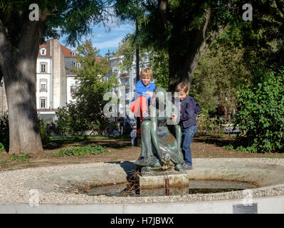 Jungs spielen am Brunnen mit jungen Mädchen und Schildkröte Bronze Skulptur 1963 des französischen Bildhauers Jean Henninger, Straßburg, Frankreich Stockfoto