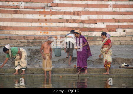 Indische Menschen mit Badewanne im Wasser des Flusses Ganges in Varanasi, Uttar Pradesh, Indien Stockfoto