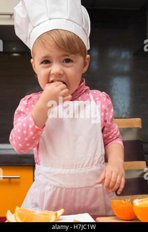 Clouse-Up Portrait kleine süße Mädchen in Chef entsprechen. Mutters Helfer. 2 Jahre alt. Stockfoto