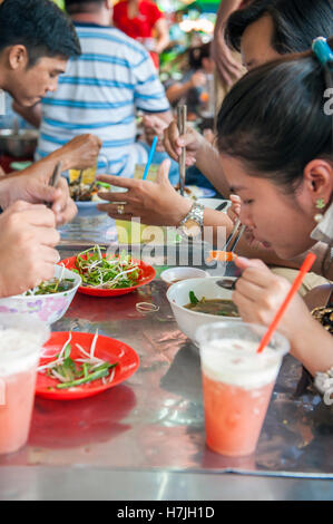 Gäste im Bürgersteig diner Bun Mam Dac San essen Bun Mam, Stechendem fermentiertem Fisch Suppe und einem Südvietnamesischen Delikatesse in Saigon. Vietnam. Stockfoto