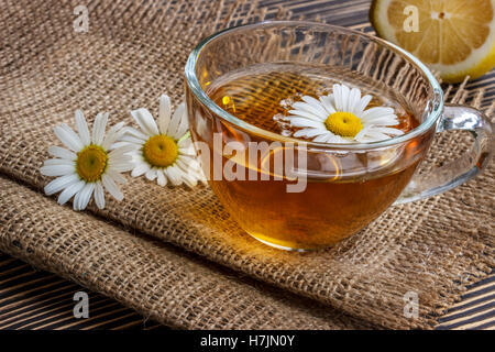 Tasse Kamillentee mit Kamillenblüten und Zitrone Stockfoto