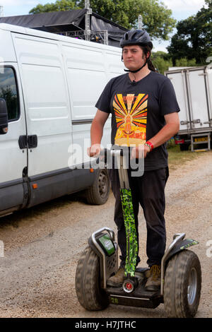 Junger Mann versucht ein Zweirad aufstehen Elektroroller zum ersten Mal, Musikfestival, Reiten Jimmys Farm, Ipswich, UK Stockfoto