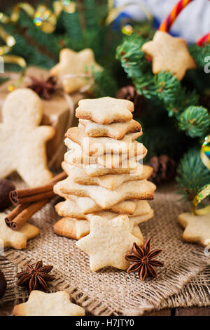 Weihnachtsplätzchen und Lametta auf dunklem Untergrund aus Holz Stockfoto