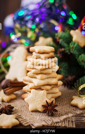 Weihnachtsplätzchen und Lametta auf dunklem Untergrund aus Holz Stockfoto