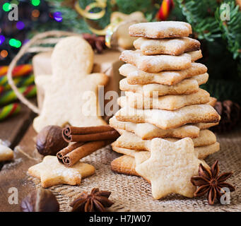 Weihnachtsplätzchen und Lametta auf dunklem Untergrund aus Holz Stockfoto