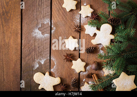 Weihnachtsplätzchen und Lametta auf einem dunklen Hintergrund aus Holz. Ansicht von oben Stockfoto