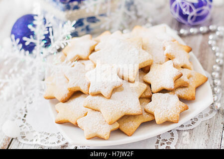 Weihnachtsplätzchen und Lametta auf einem hölzernen Hintergrund Stockfoto