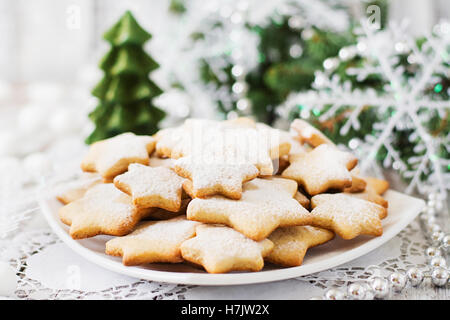 Weihnachtsplätzchen und Lametta auf einem hölzernen Hintergrund. Stockfoto