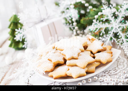 Weihnachtsplätzchen und Lametta auf einem hölzernen Hintergrund. Stockfoto