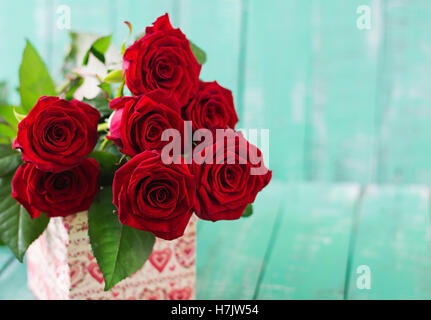 Strauß roter Rosen auf einem hölzernen Hintergrund. Stockfoto