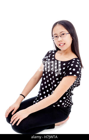 Asiatische Tween Mädchen in eine kniende Pose, isoliert auf weißem Hintergrund Stockfoto