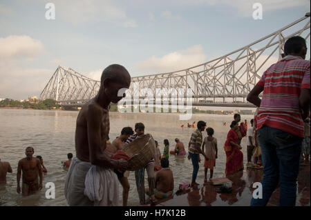 Menschen nehmen morgendlichen Bad in Hooghly River in der Nähe von Howrah Brücke (Rabindra Setu) bei Mallick Ghat Kolkatat Indien Stockfoto