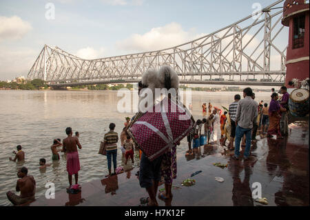 Menschen nehmen morgendlichen Bad in Hooghly River in der Nähe von Howrah Brücke (Rabindra Setu) bei Mallick Ghat Kolkatat Indien Stockfoto