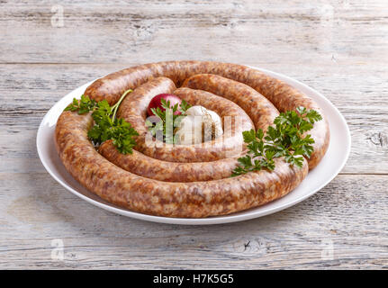 Rohe Bratwurst auf weißen Teller Stockfoto