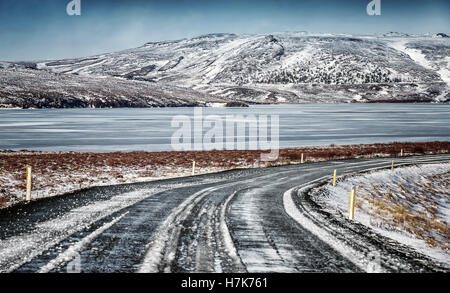 Schöne Winter-Ansicht, Autobahn in der wilden Natur Islands, schöne Aussicht auf die Berge mit Schnee bedeckt Stockfoto