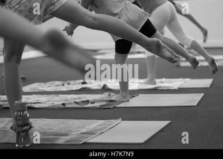 Reihe von monochromen Fotografien in einem Yogastudio. Diese Bilder zeigen ein Kind Yoga-Kurs. Stockfoto