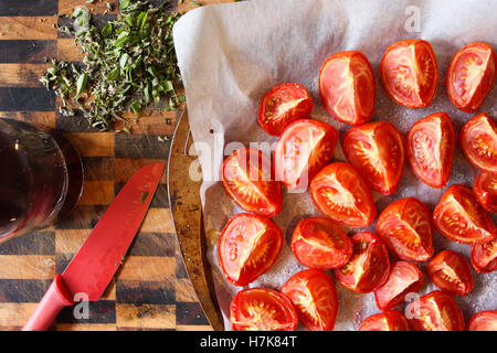 Hausgemachte Ofen gerösteten Tomaten, mit frischen Kräutern und Rotwein-Essig auf der Seite. Stockfoto