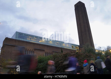 Menschen zu Fuß entlang der Londoner Southbank mit Tate Modern im Hintergrund Stockfoto