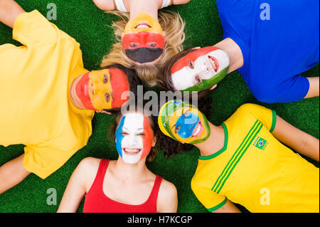 Junge Menschen mit Gesichtern bemalt in verschiedenen Nationalfarben Stockfoto