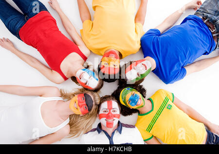 Junge Menschen mit Gesichtern bemalt in verschiedenen Nationalfarben Stockfoto