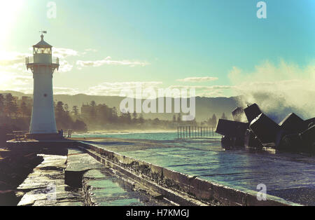 Große Wellen brechen über Wollongong Hafen Breakwall und Leuchtturm, Wollongong, New-South.Wales, Australien Stockfoto