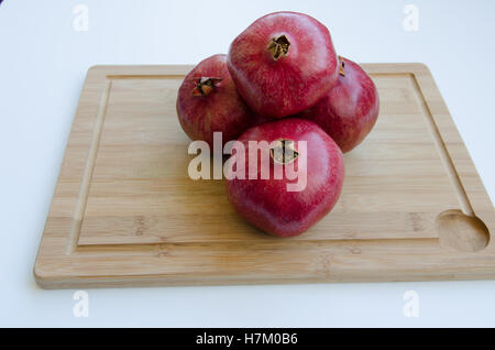 Stapel von Granatapfel-Frucht auf Schneidebrett Stockfoto